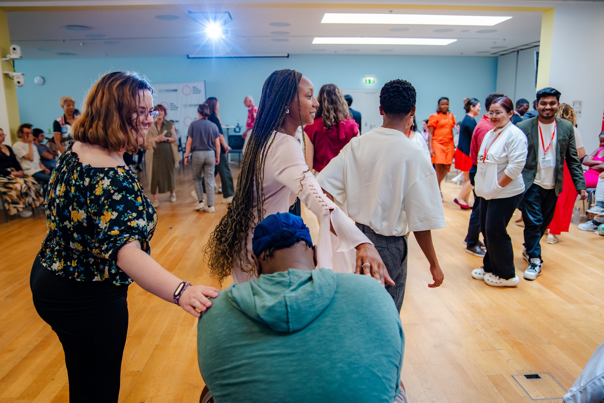 Two students tapping a shoulder of a third student as a part of an activie at Get Engaged 2023
